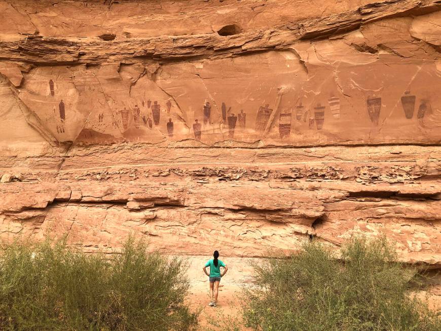 A hiker pauses to view the Great Gallery, a 200-foot panel of ancient drawings along the dry c ...