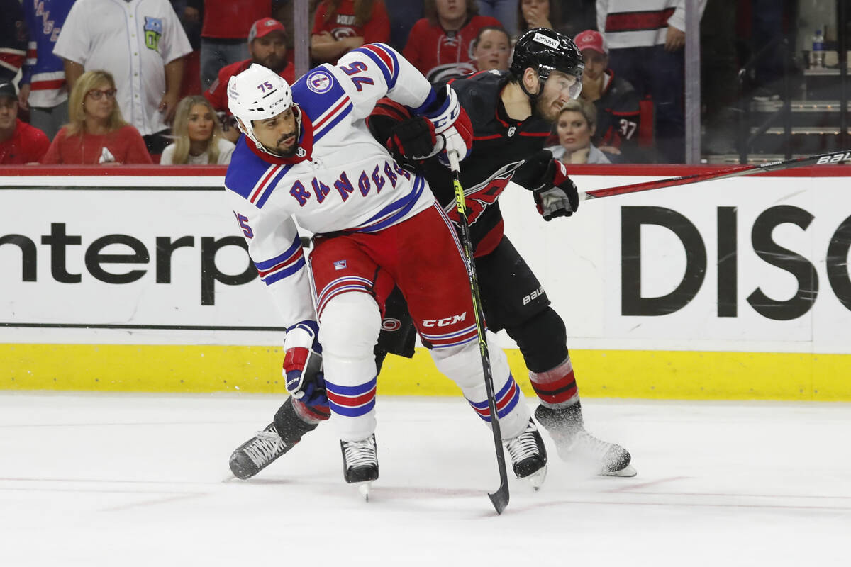 New York Rangers' Ryan Reaves (75) tangles with Carolina Hurricanes' Brett Pesce (22) during th ...