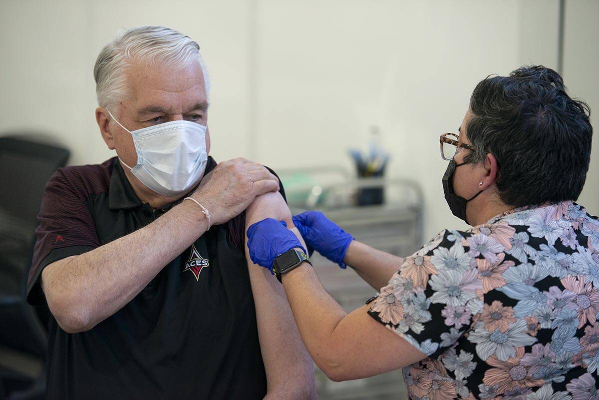 Nevada Gov. Steve Sisolak gets a bandage from nurse KJ Dionisio after receiving his second COVI ...