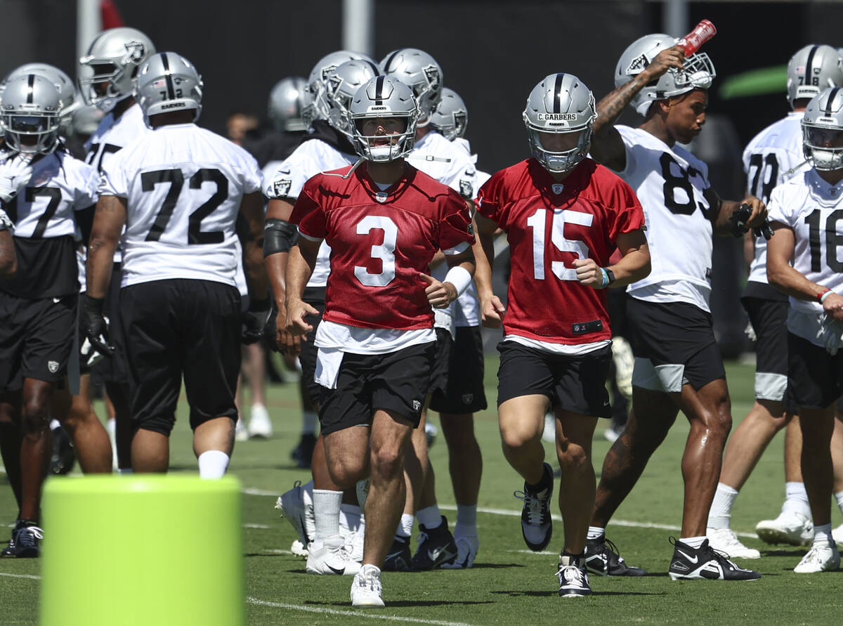 Raiders quarterbacks Jarrett Stidham (3) and Chase Garbers (15) participate during practice at ...