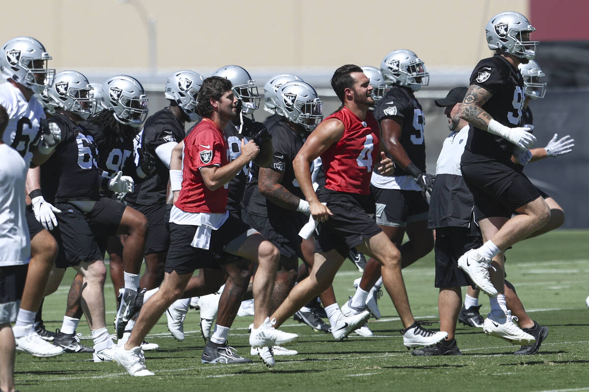 Raiders quarterbacks Jarrett Stidham, left, in red, Derek Carr (4) and defensive end Maxx Crosb ...