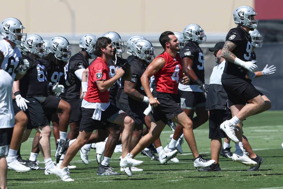 Raiders quarterbacks Jarrett Stidham, left, in red, Derek Carr (4) and defensive end Maxx Crosb ...