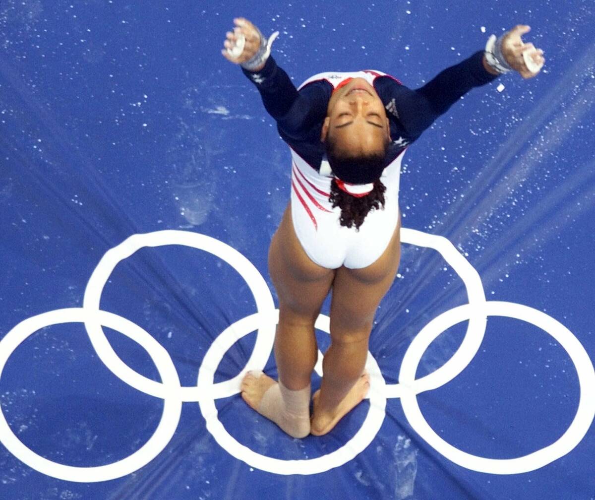 FILE - USA gymnast Tasha Schwikert sticks her landing on the uneven bars during the women's gym ...