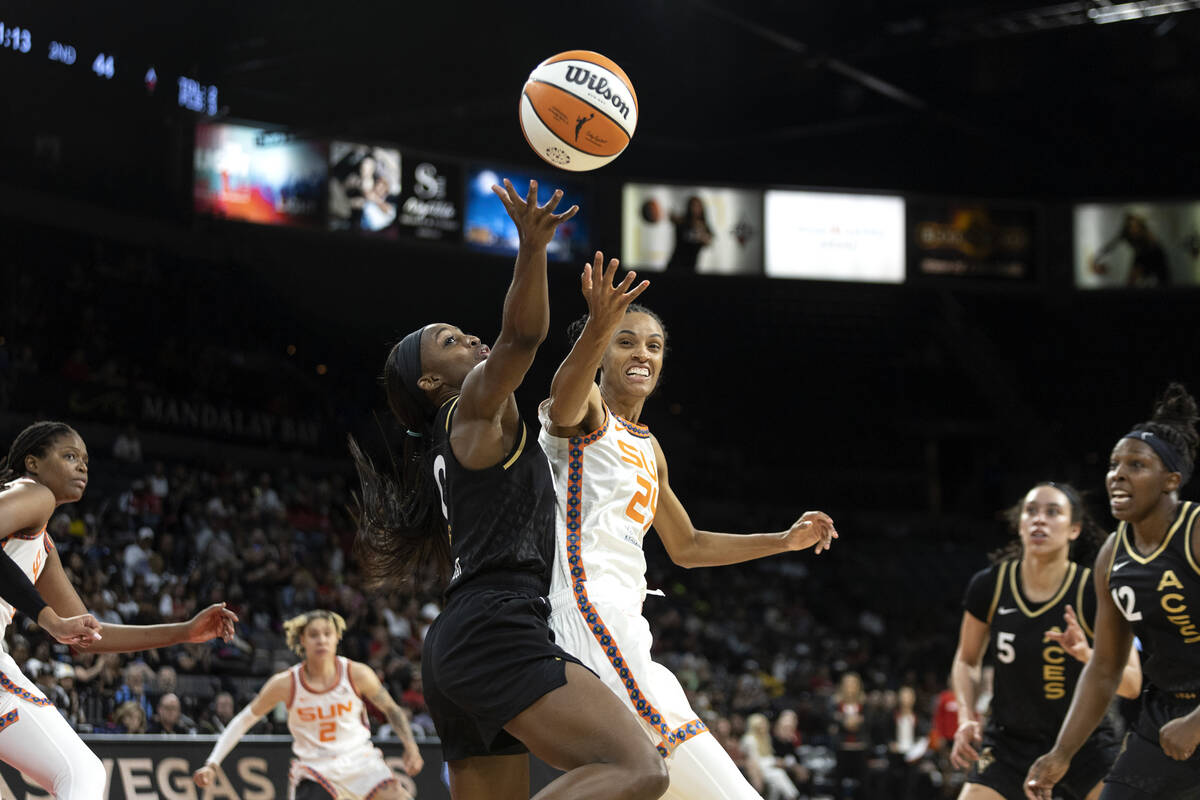 Las Vegas Aces guard Jackie Young (0) knocks down a shot by Connecticut Sun forward DeWanna Bon ...