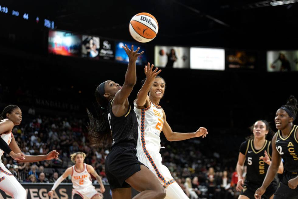 Las Vegas Aces guard Jackie Young (0) knocks down a shot by Connecticut Sun forward DeWanna Bon ...