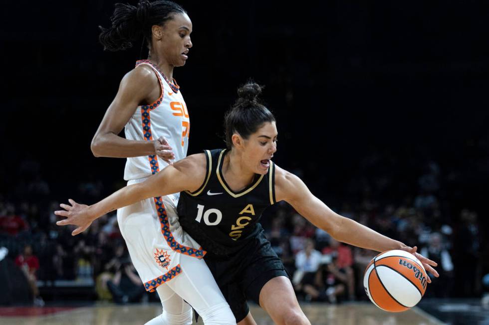 Las Vegas Aces guard Kelsey Plum (10) drives around Connecticut Sun forward DeWanna Bonner (24) ...