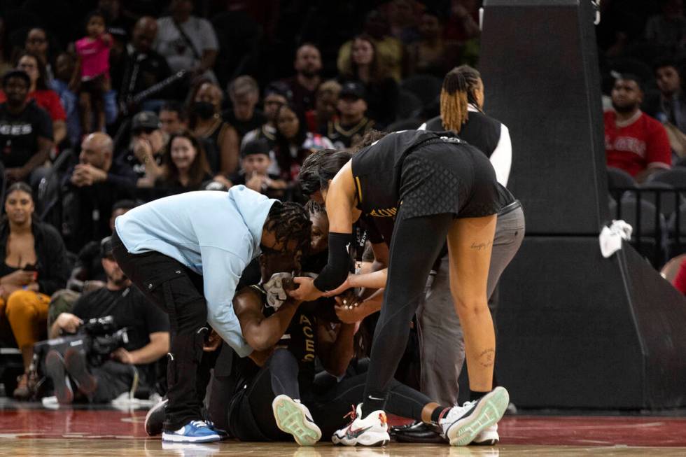 Las Vegas Aces players surround guard Chelsea Gray after she was injured during the second half ...