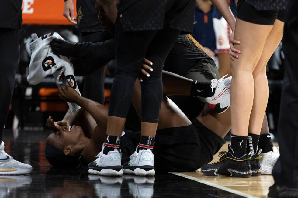 Las Vegas Aces guard Jackie Young (0) is surrounded by teammates and staff after getting injure ...