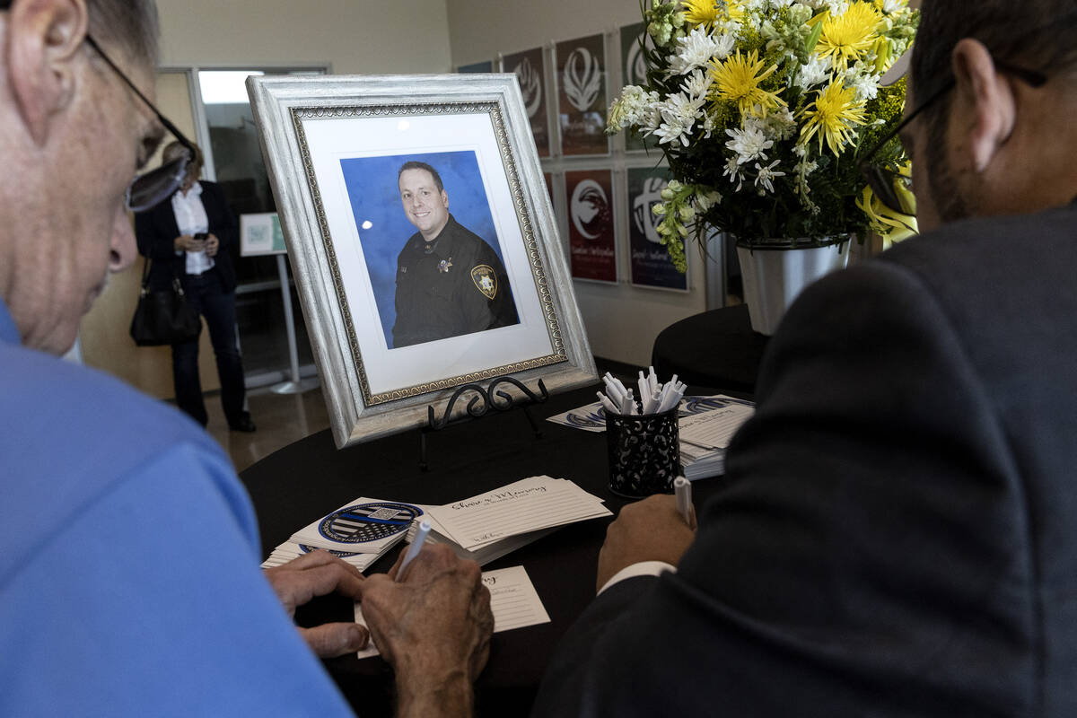 Mourners write their condolences during a funeral for Officer Phil Closi, a Metropolitan police ...