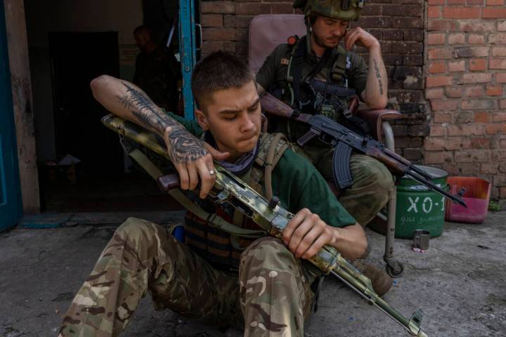 A security member of a medical rescue team cleans his weapon in the Donetsk oblast region, east ...