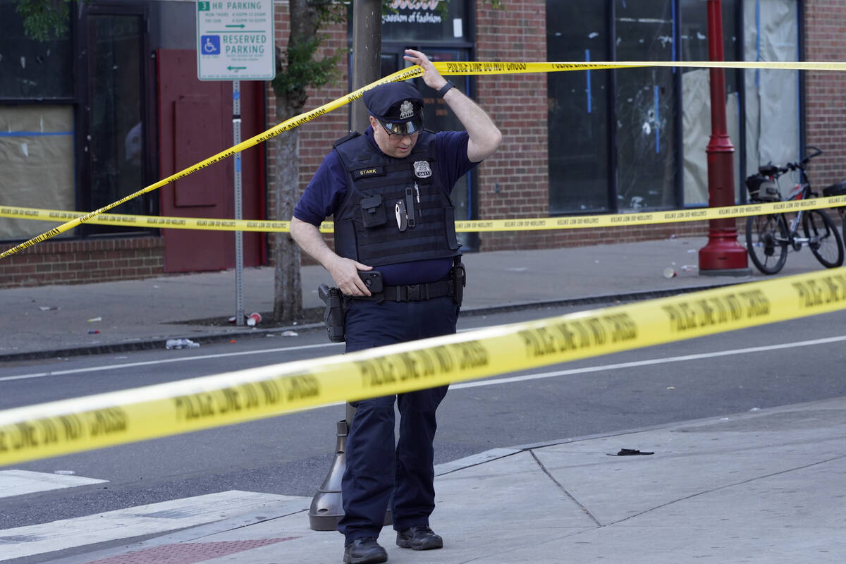 Philadelphia Police investigators work the scene of a fatal overnight shooting on South Street ...