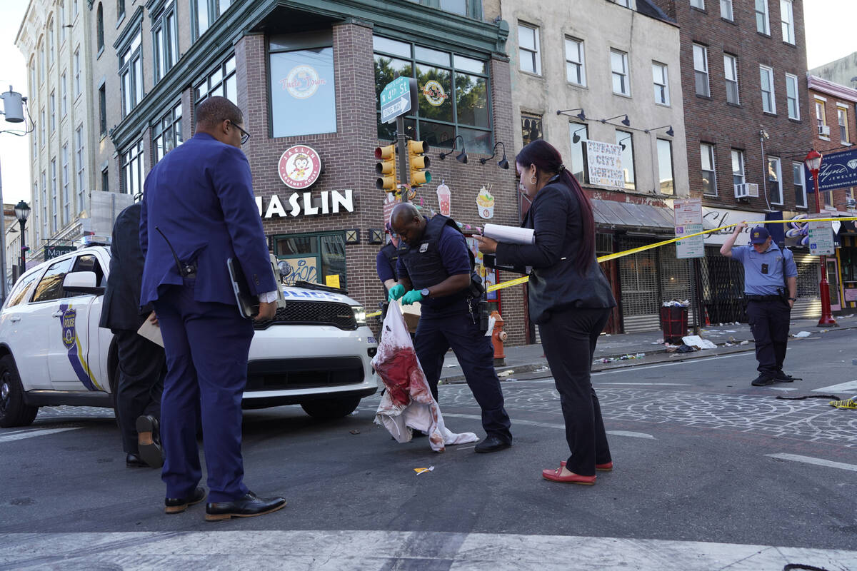 Philadelphia Police Investigators work the scene of a fatal overnight shooting on South Street ...