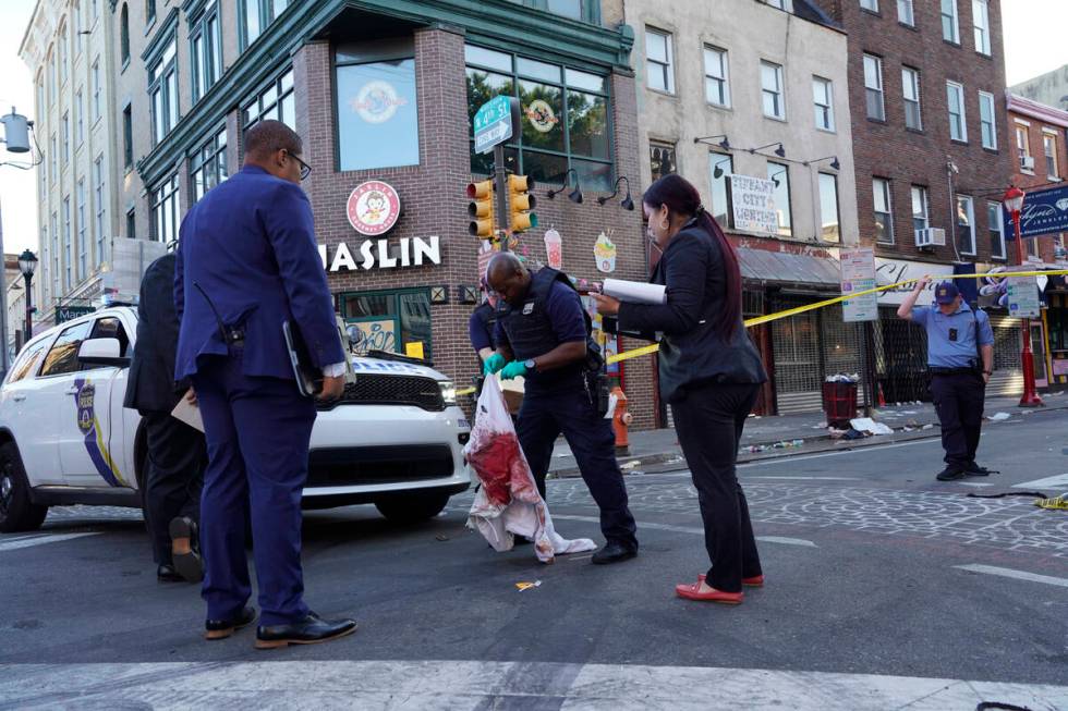 Philadelphia Police Investigators work the scene of a fatal overnight shooting on South Street ...