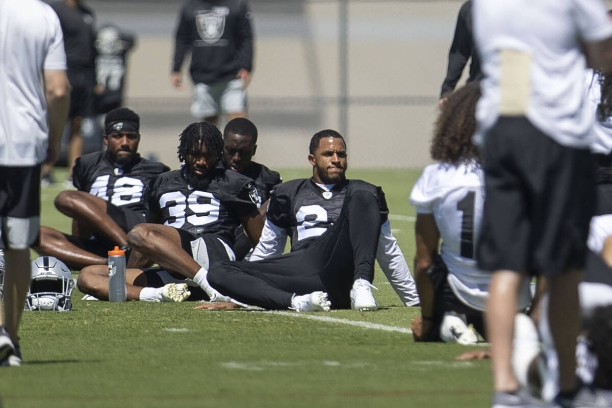 Raiders safety Johnathan Abram (24) and cornerback Nate Hobbs (39) stretch during a team practi ...