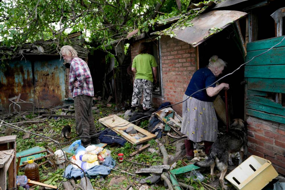 Residents recover belongings from their damaged home after a strike in Druzhkivka, Ukraine, Sun ...