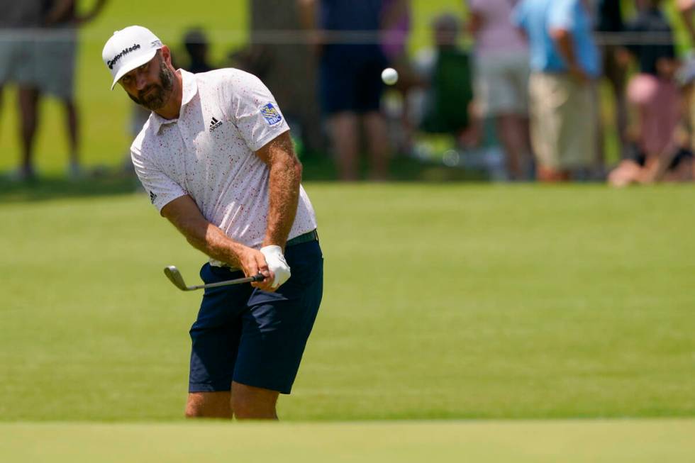 Dustin Johnson chips to the green on the first hole during a practice round for the PGA Champio ...