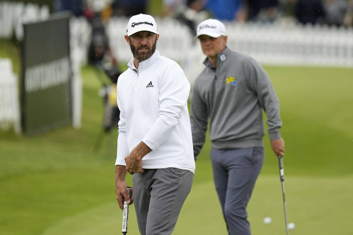 Dustin Johnson of the United States stands on the practice green before the first round of the ...
