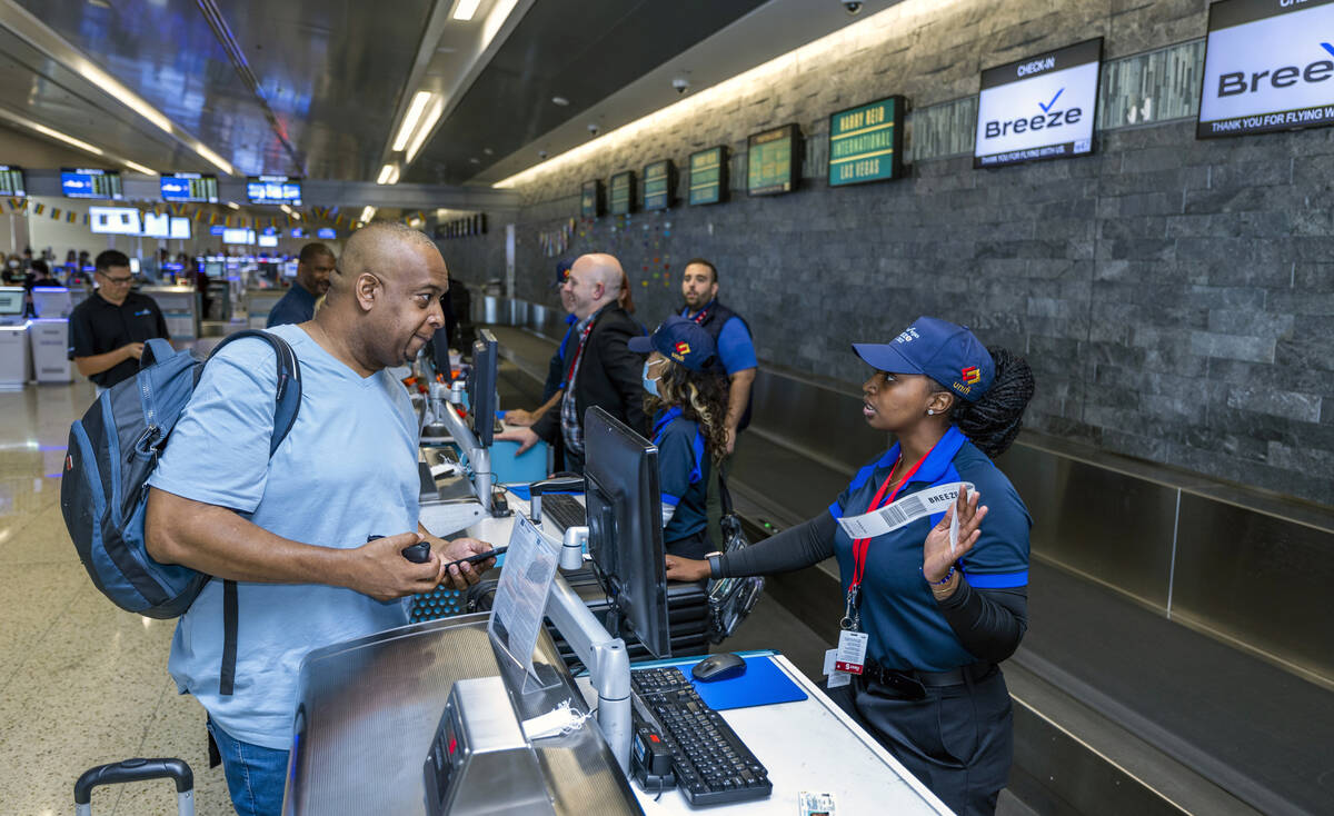 Passenger Antoine Scott, left, of Las Vegas talks with Breeze Airways ticketing agent Treyona C ...