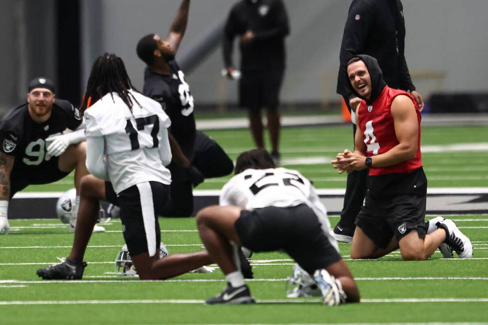 Raiders quarterback Derek Carr, right, shares a laugh with wide receiver Davante Adams (17) as ...