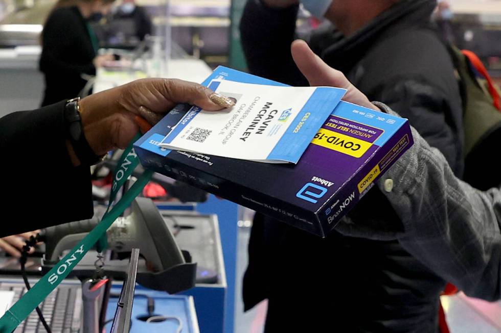 Cavin McKinley of Oak Brook, Ill. picks up his CES badge and COVID-19 test kit after landing at ...