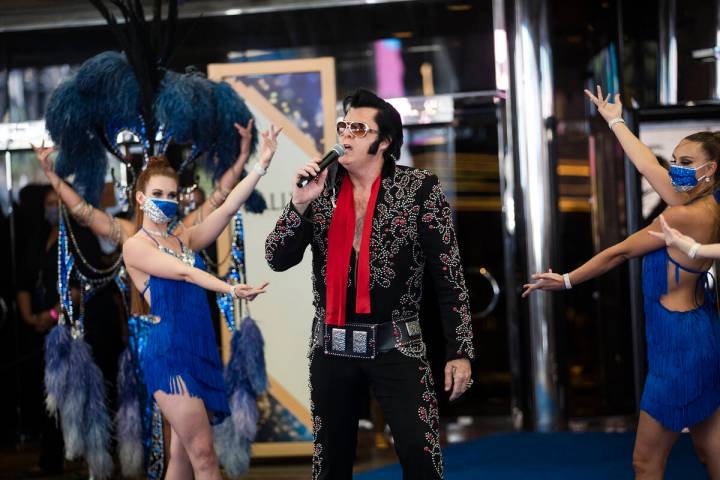 Brendan Paul, impersonating Elvis Presley, addresses the crowd alongside dancers at the reopeni ...