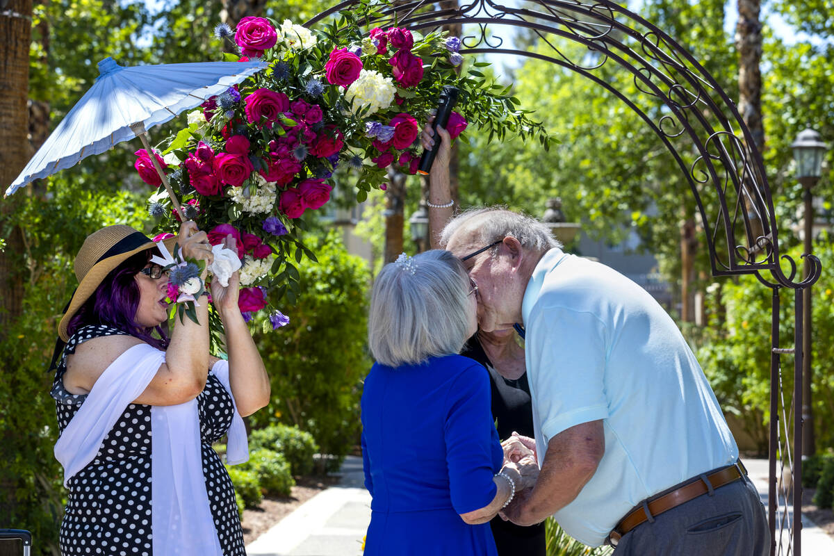 Bride Carolyn Brylinski, center, shares a kiss with groom John Hansell, right, after being marr ...