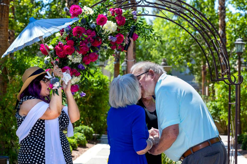 Bride Carolyn Brylinski, center, shares a kiss with groom John Hansell, right, after being marr ...