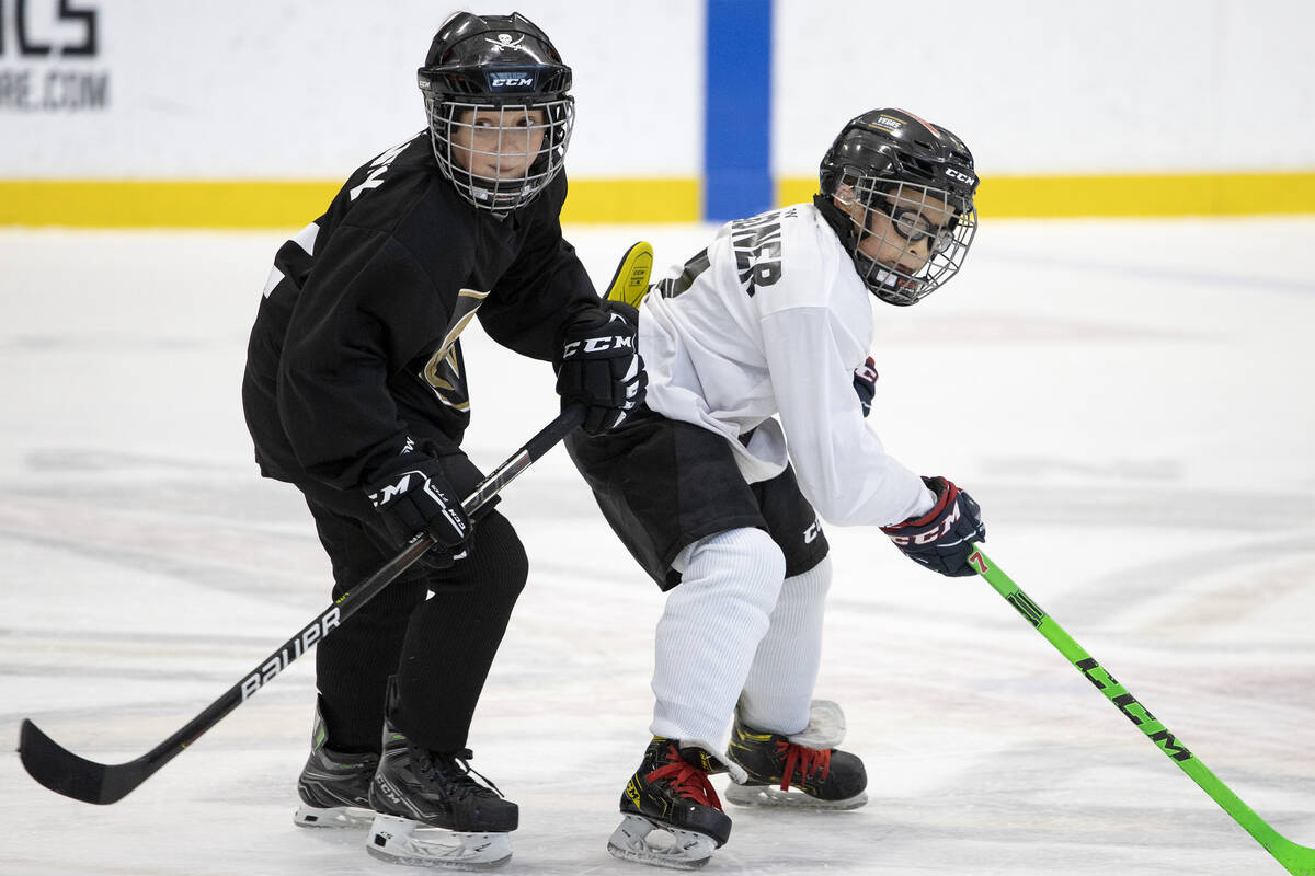 Goonies player Myles Chaney, left, and Mavericks player Mitchell Gardner compete for the puck d ...