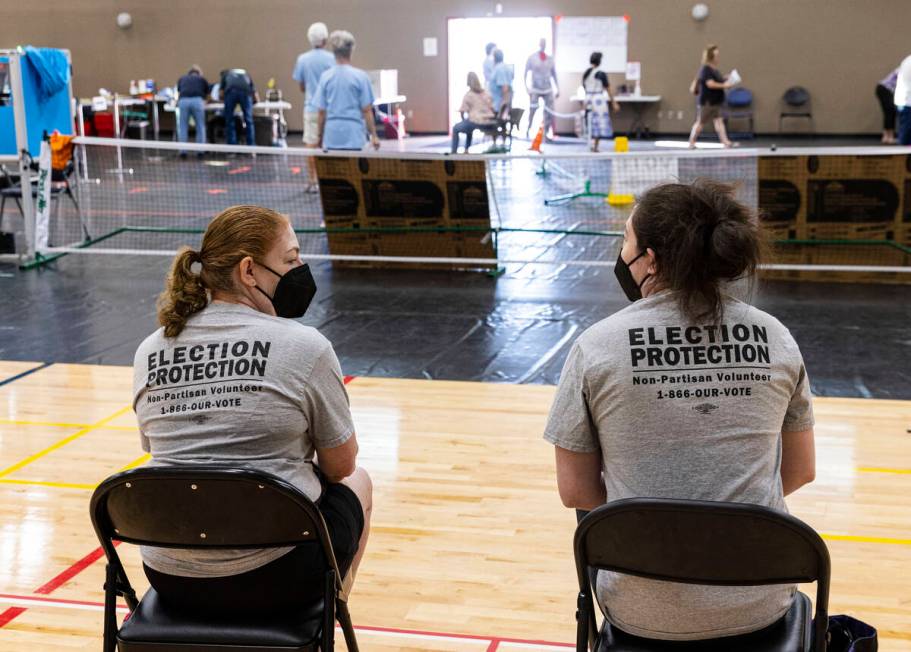 Election observers, who declined to give their names, watch as voters cast their ballots at a p ...