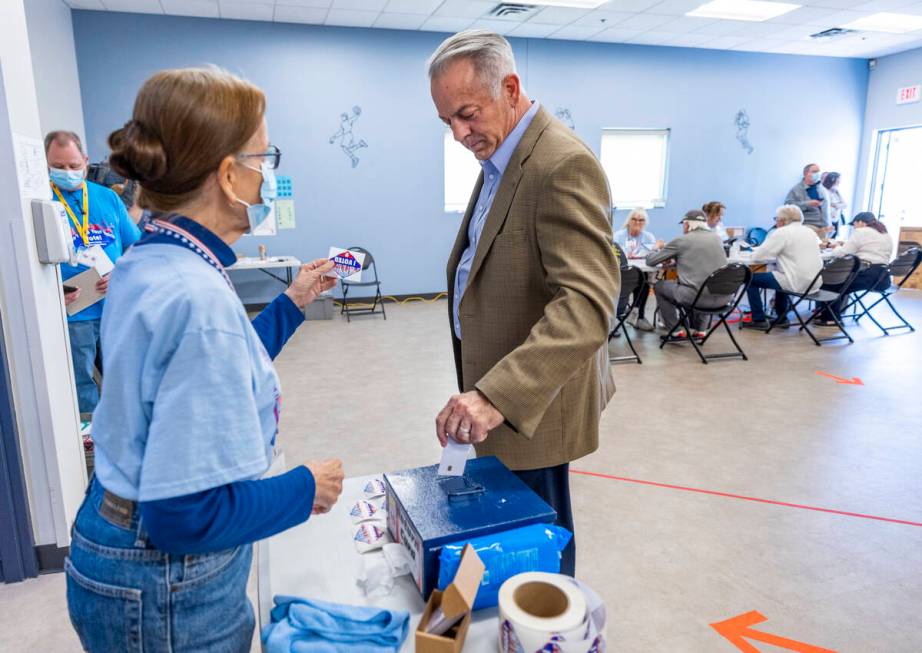 Sheriff Joe Lombardo inserts his vote card while getting a sticker after voting during the Neva ...