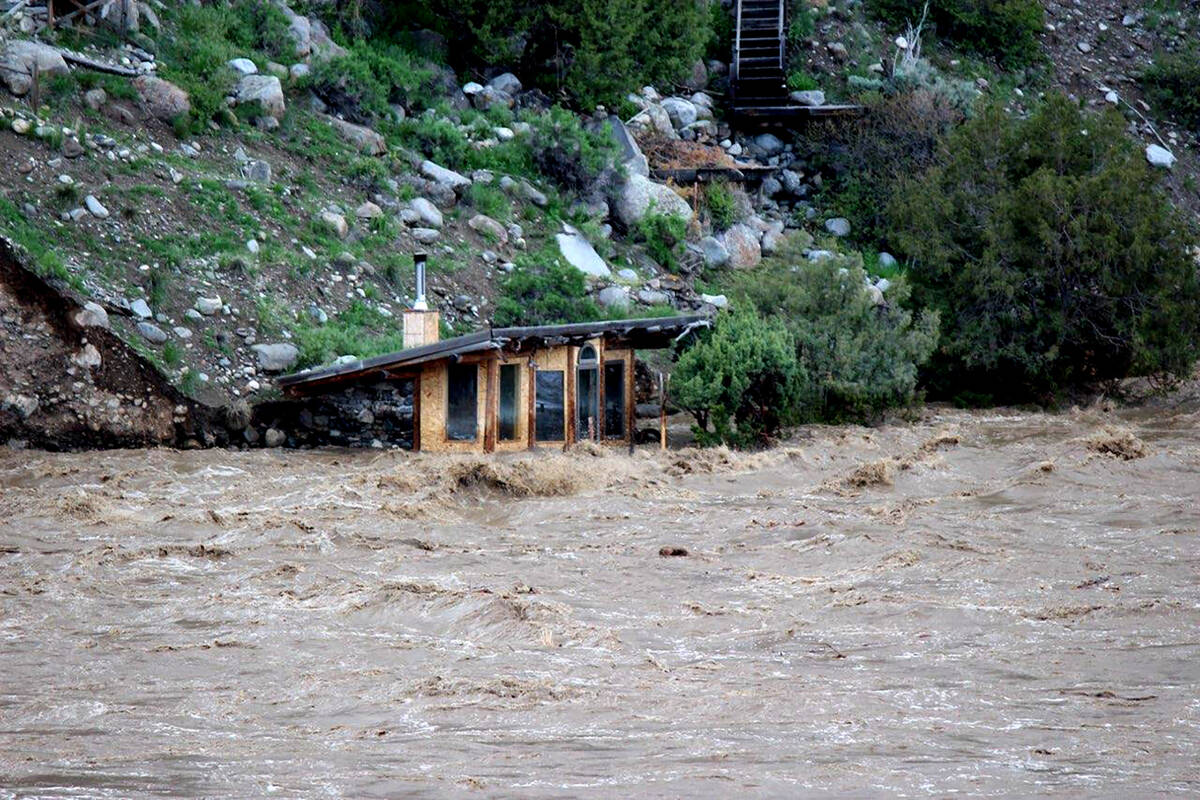 In this photo provided by Sam Glotzbach, the fast-rushing Yellowstone River flooded what appear ...