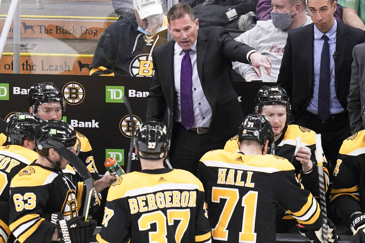 Boston Bruins head coach Bruce Cassidy, top center, talks with his players during a timeout lat ...
