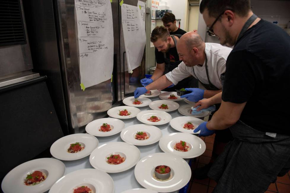 Chef Jeffrey Weiss, center, garnishes the first dish, a tuna tartare with crab, watermelon gran ...