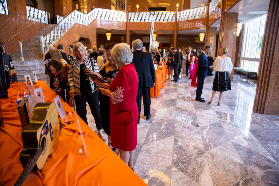 People browse the auction items during the Las Vegas Philharmonic’s fundraising event at ...