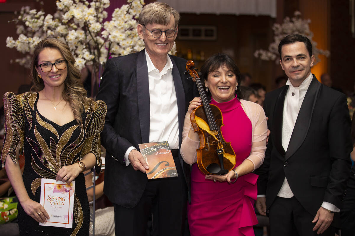 Elena Gliga, far left, and her husband Cristian, far right, pose with a photo with Fritz Kummer ...