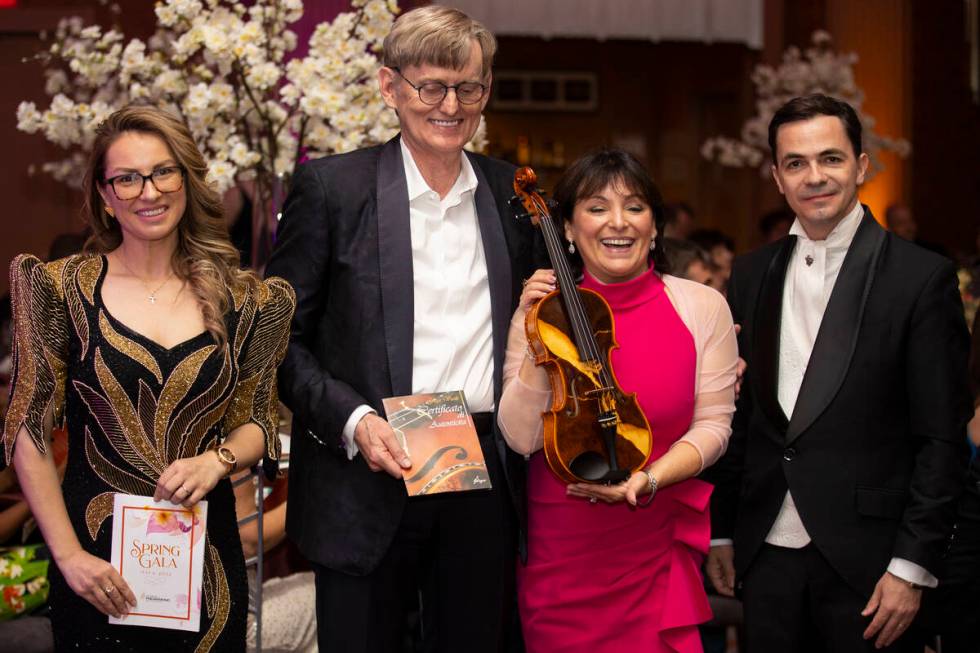 Elena Gliga, far left, and her husband Cristian, far right, pose with a photo with Fritz Kummer ...