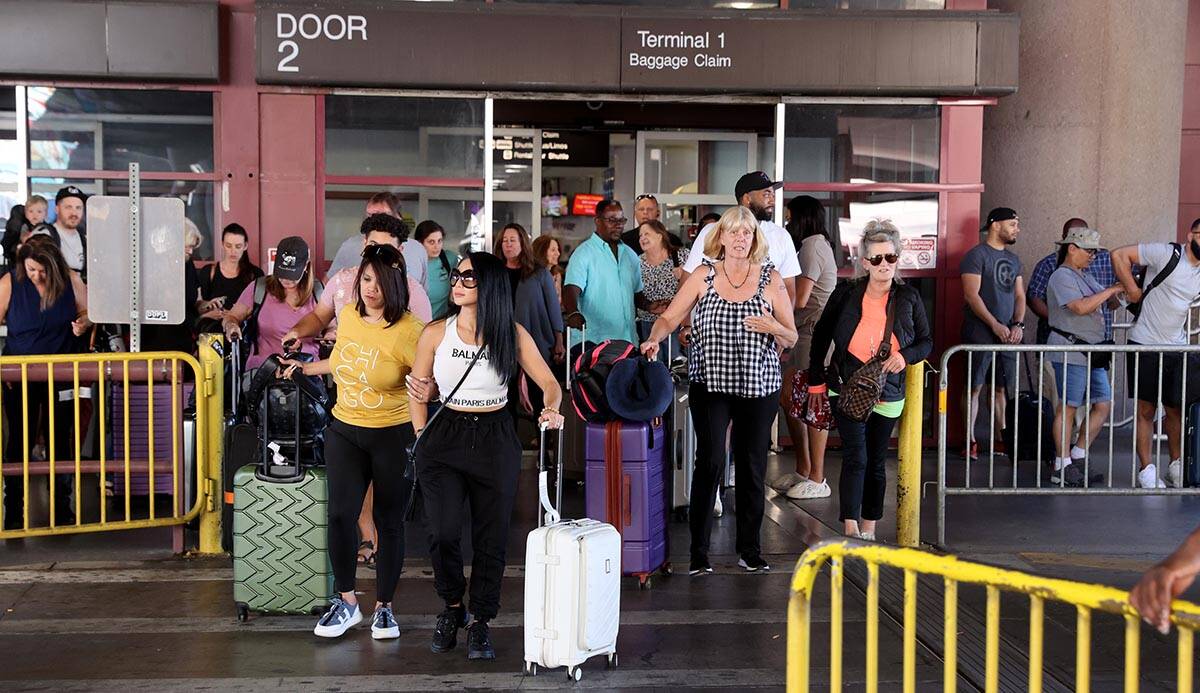 Passengers walk out of baggage claim in Terminal 1 at Harry Reid International Airport Wednesda ...