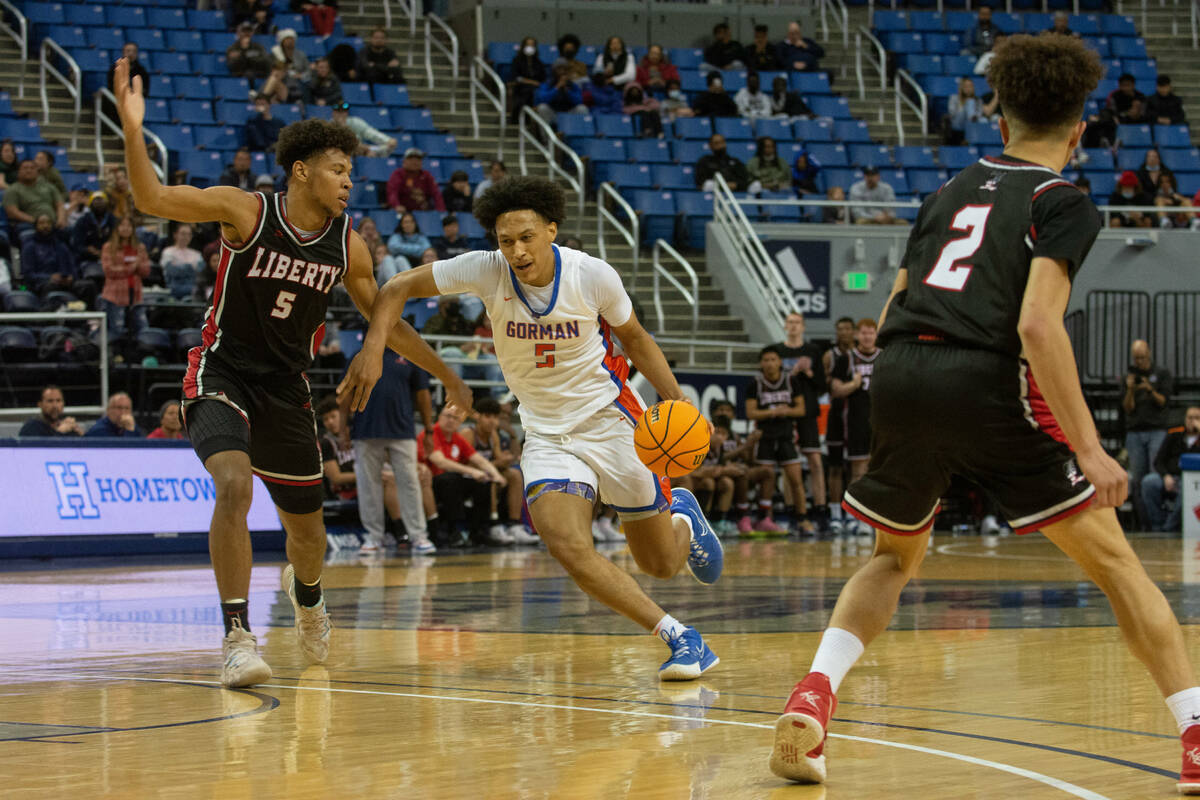 Bishop Gorman's Darrion Williams dribbles into Liberty defender Joshua Jefferson during the NIA ...
