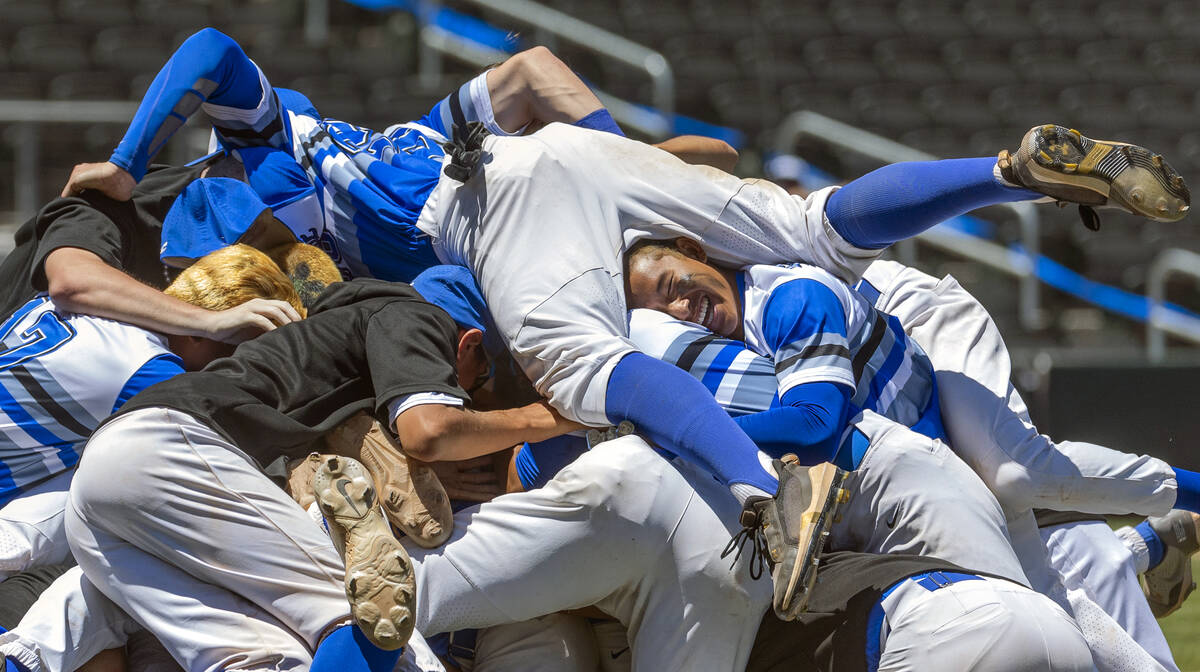 Basic players "dog pile" on the pitcher's mound in celebration of defeating Bishop Go ...