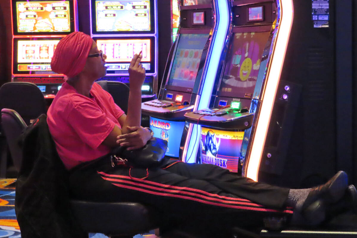 A gambler smokes while playing a slot machine at the Ocean Casino Resort on Feb. 10, 2022, in A ...