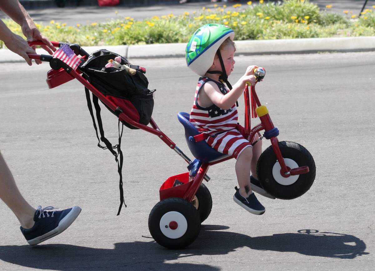 Aiden McCormick, 2, is pushed on a tricycle by his father during the 2005 Summerlin Council Pat ...
