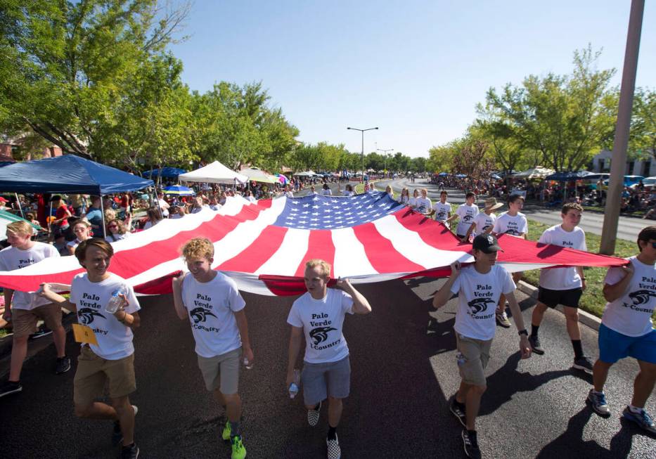 Members of the Palo Verde High School track team march with a giant American flag during the 20 ...