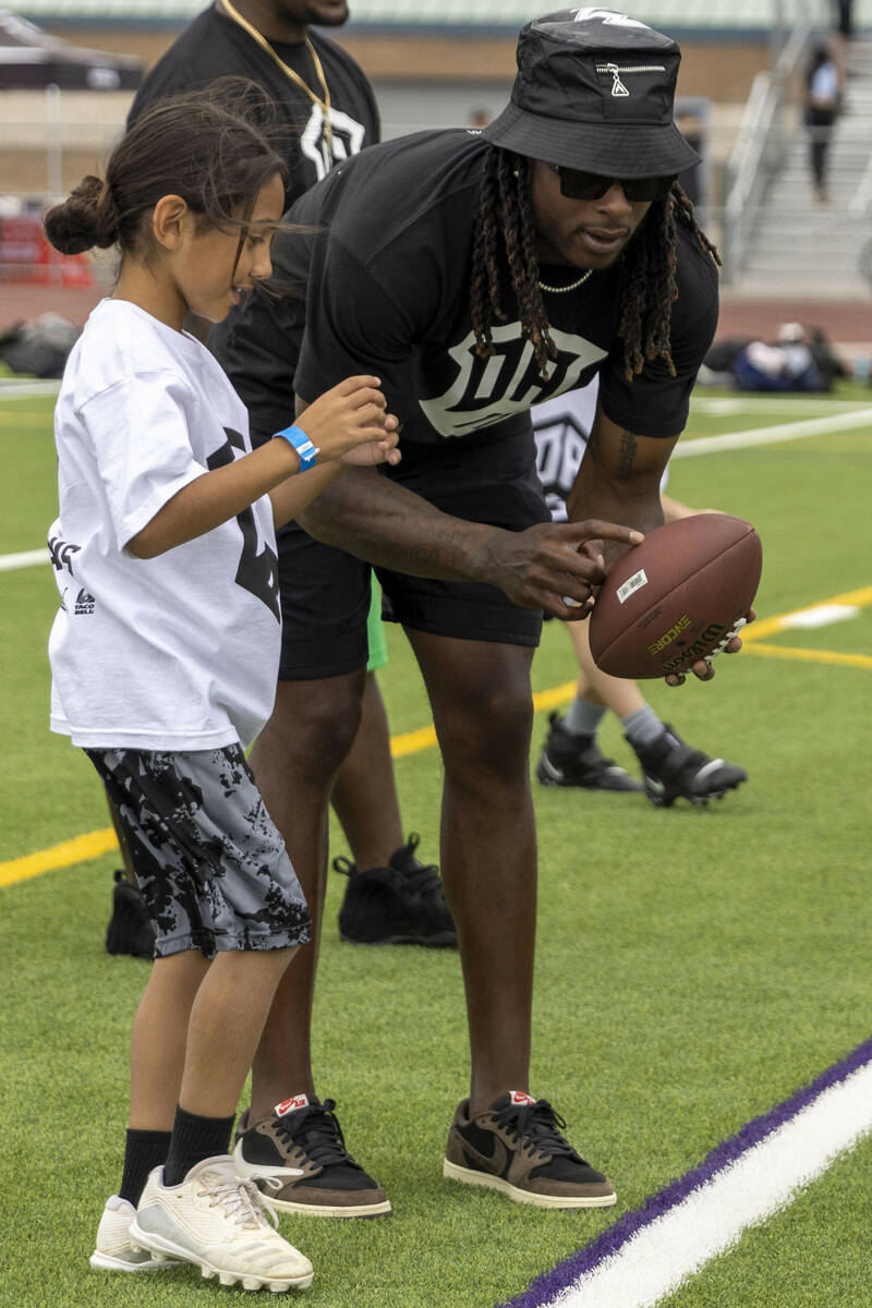 Raiders wide receiver Davante Adams coaches a young athlete at his youth football camp at Sprin ...