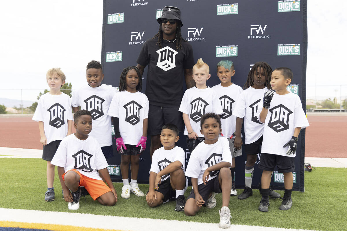 Raiders wide receiver Davante Adams, center, poses with a group of young athletes at his youth ...