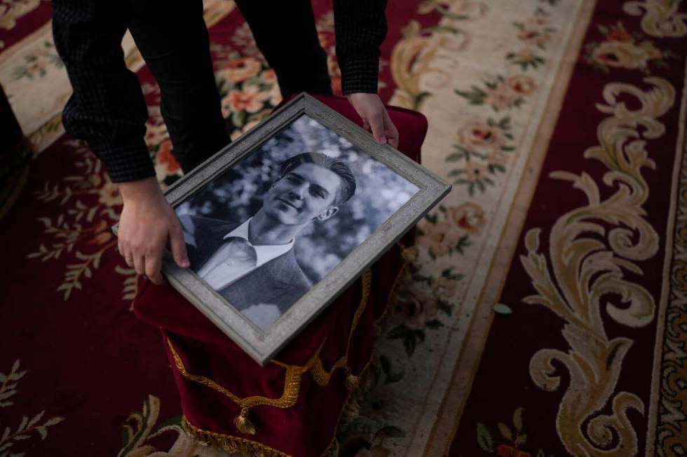 A man holds a photo of activist and soldier Roman Ratushnyi before the start of the memorial se ...