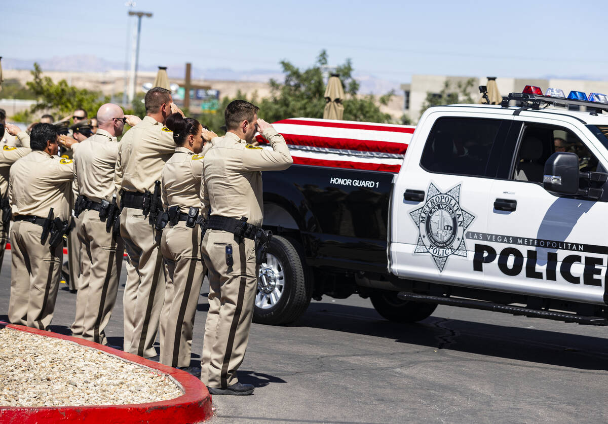 Metropolitan Police Department officers salute as the honor guard vehicle carrying the casket o ...