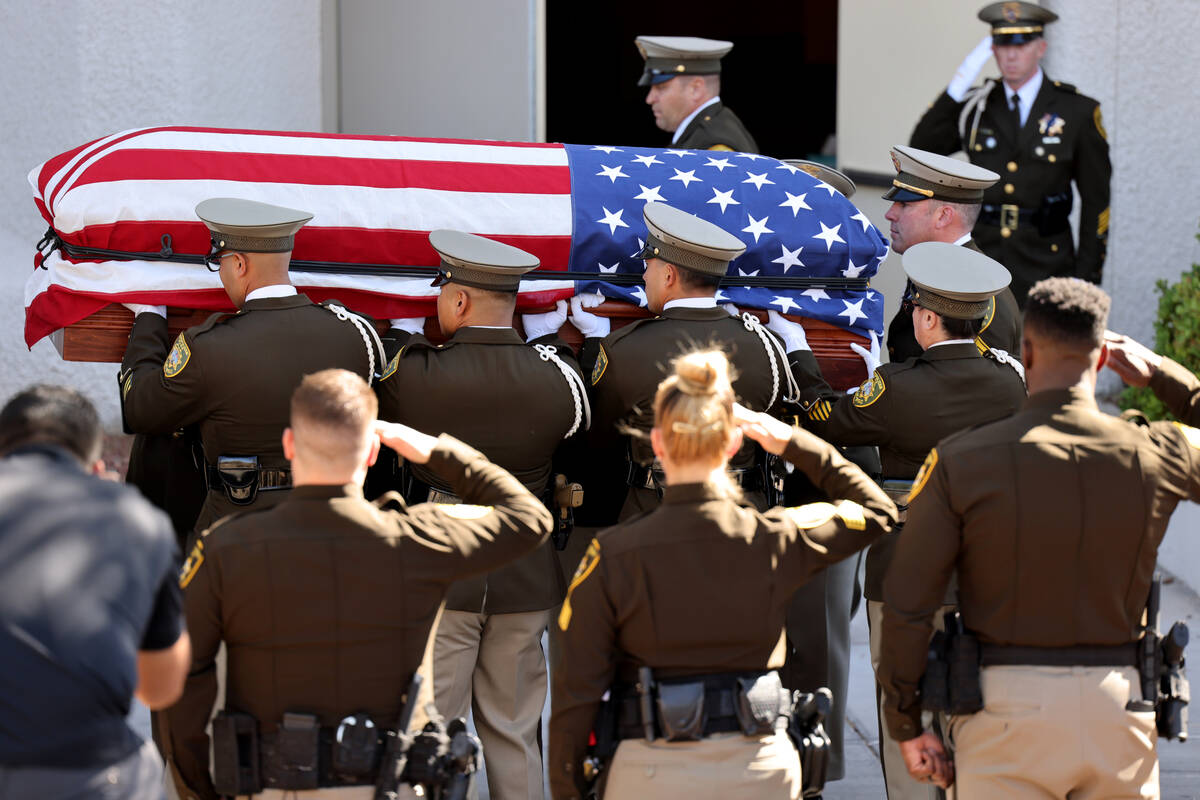 A Metropolitan Police Department honor guard loads the casket of Las Vegas police Detective Jus ...