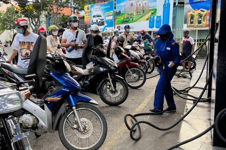 People wait for gas pump in Hanoi, Vietnam Sunday, June 19, 2022. Across the globe, drivers are ...