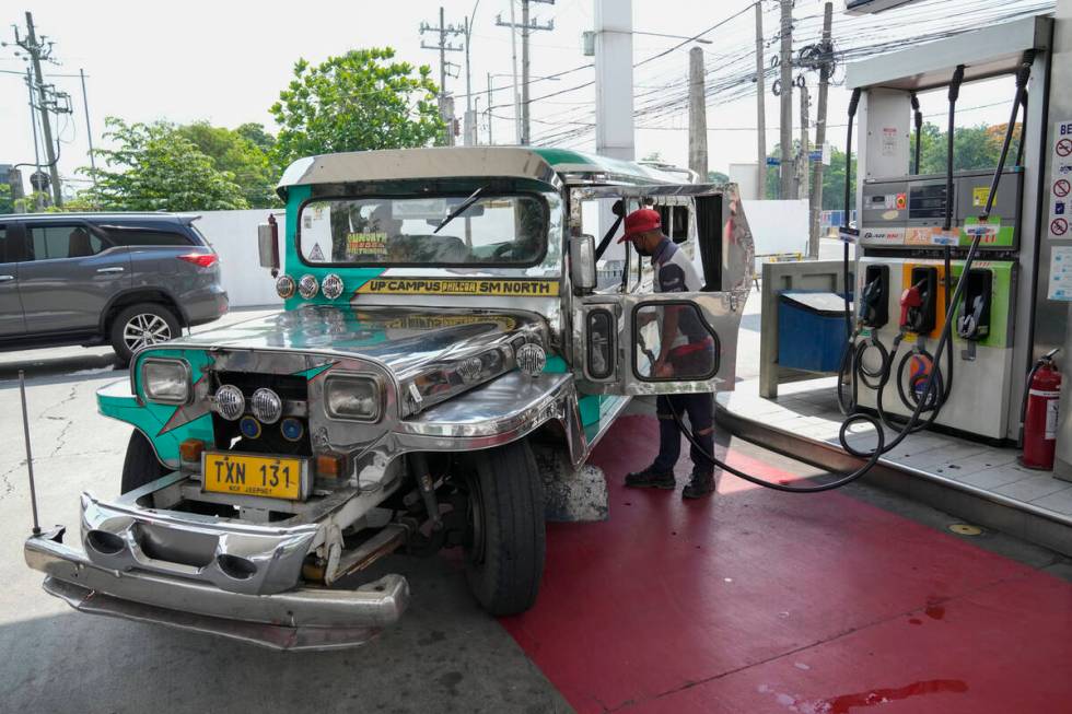 A passenger jeepney driver refuels his vehicle at a gasoline station in Quezon City, Philippine ...
