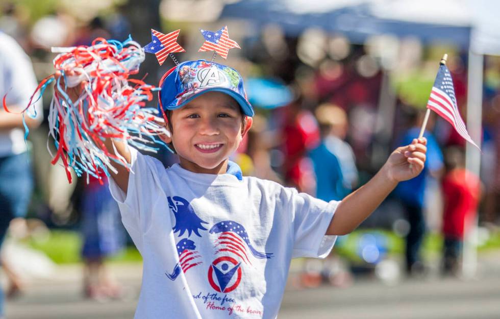 In this July 4, 2017, file photo, a young parade goer waves to crowds as he marches in the para ...